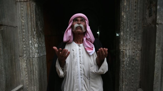 Sheikh Mirza, 84, prays at the entrance to the temple of Lalis, the holiest site of the Yazidi religion last week in Nineveh Province, Iraq. 