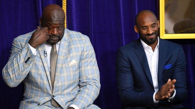Shaquille O'Neal, left, wipes tears from his eyes as he sits next to Kobe Bryant at the unveiling of a statue.