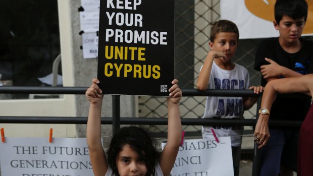 A girl holds up a board  during a peace protest in the divided capital of Nicosia, Cyprus, on  July 6. 