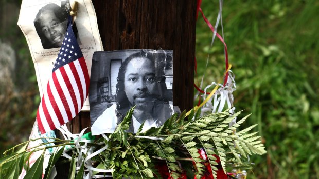 Photos of Samuel DuBose hang on a pole at a memorial near where he was shot and killed. 