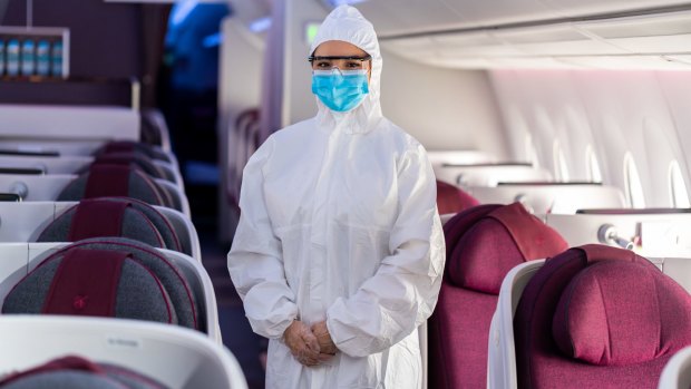 A flight attendant wearing protective equipment on board Qatar Airways. Akbar Al Baker, chief executive of the airline, says the pandemic will force a mindset shift similar to how 9/11 transformed aviation security procedures.