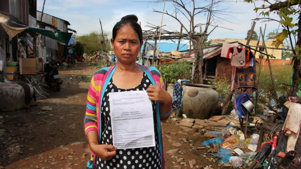 Cambodian surrogate mother Hour Vanny, holding the two-page document she signed with Fertility Solutions, operated by Australian nurse Tammy Davis-Charles. 