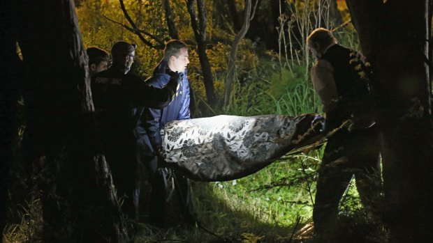 Police remove the body of a woman from bushland in Donvale.