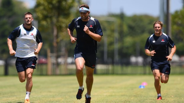 Rob Horne, Dean Mumm and Michael Hooper of the Waratahs during a fitness drill on Wednesday.