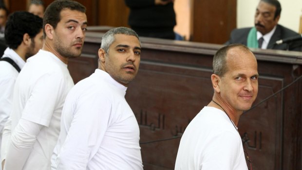 Mohamed Fahmy, centre, with Baher Mohamed, left, and Peter Greste, right, in court in March 2014. 