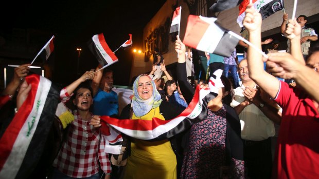 Iraqis celebrate in Baghdad's Tahrir Square after Prime Minister Haider al-Abadi declares victory against the Islamic State in Mosul.