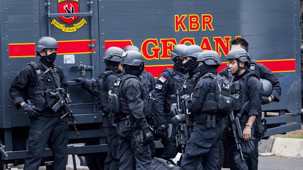 Indonesian police guard the blast site after a series of explosions hit the Indonesia capital.