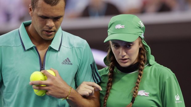 Jo-Wilfried Tsonga helps injured ballgirl Giuliana off the court at last year's Australian Open.