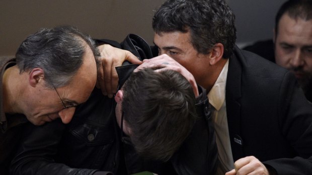 French cartoonist Renald Luzier is comforted by the Editor in Chief of <i>Charlie Hebdo</i>, Gerard Briard (left) and editorialist Dr Patrick Pelloux, during a press conference to present the new issue in Paris.
