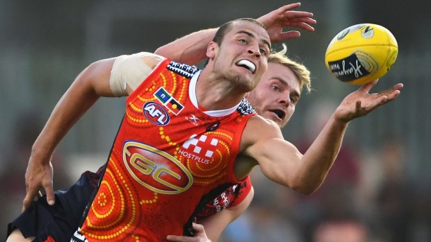 Gold Coast's Jarrod Witts competes with Melbourne's Jack Watts.