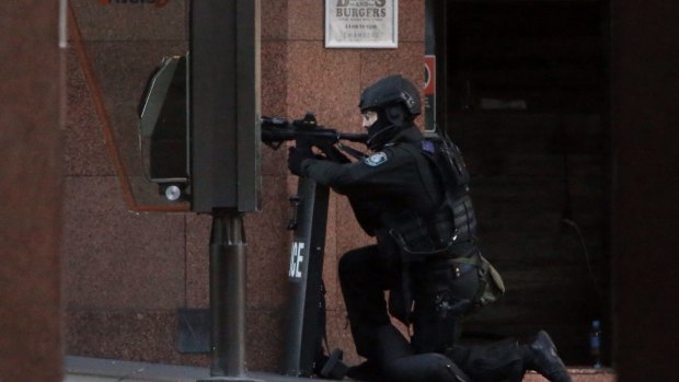 A NSW Tactical Operations Group police officer maintains his position at the scene in Martin Place, Sydney.