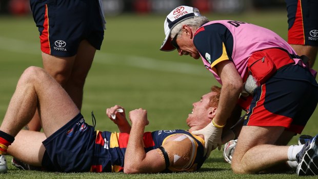 Adelaide's Tom Lynch is attended to after being concussed in Sunday's NAB Challenge match.