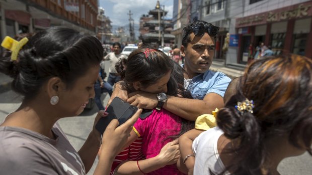 Local residents comfort each others during an earthquake in central Kathmandu.