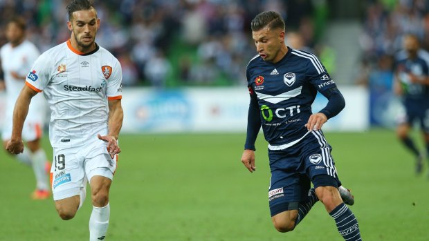 Kosta Barbarouses of Melbourne Victory (right) ponders his next move aas Jack Hingert of Brisbane Roar approaches.