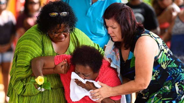 Grief at the scene of a temporary memorial to eight children killed in a Cairns house.