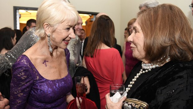 Actress Helen Mirren, left, sports a Prince tribute as she speaks with Teresa Heinz Kerry, wife of US Secretary of State John Kerry, at the Bloomberg cocktail party before the dinner.