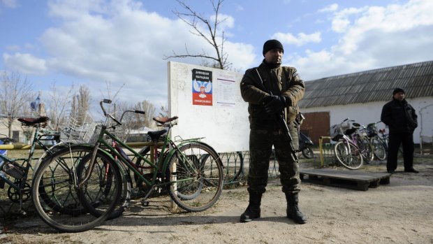 A pro-Russian militant guards a polling station in Novoazovsk, eastern Ukrainian.