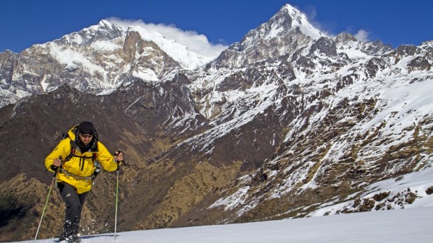 Trekking through snow on Kopra Ridge, with Annapurna I and Annapurna South behind Kopra high.