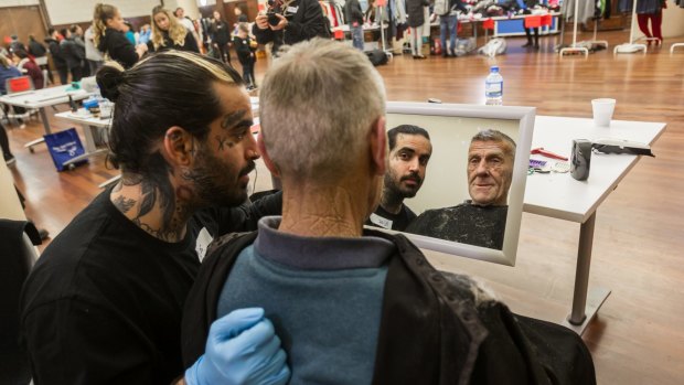 Picture of you: Barber Nasir Sobhani  gives homeless man Max a haircut at a volunteer-run Christmas on the Streets event in the Drill Hall in the city on Sunday.