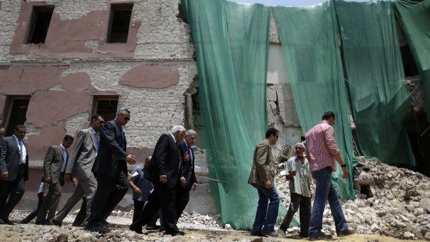 Egyptian Prime Minister Ibrahim Mehleb, fourth right, the area damaged by last week's bombing outside the Italian Consulate in, Cairo.