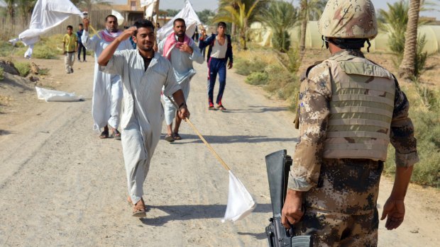 Villagers welcome Iraqi soldiers on Monday after the defeat of IS in villages outside Ramadi, 115km west of Baghdad.