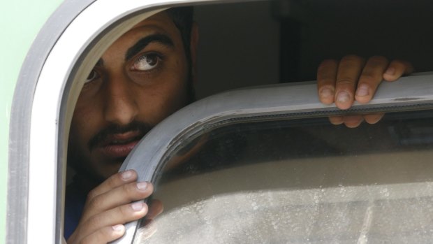 A man looks out from the window of the train in Bicske.