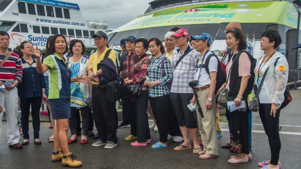Chinese tourists meet cruise co-ordinator Jennifer Yu before boarding for the Great Barrier Reef in Cairns.