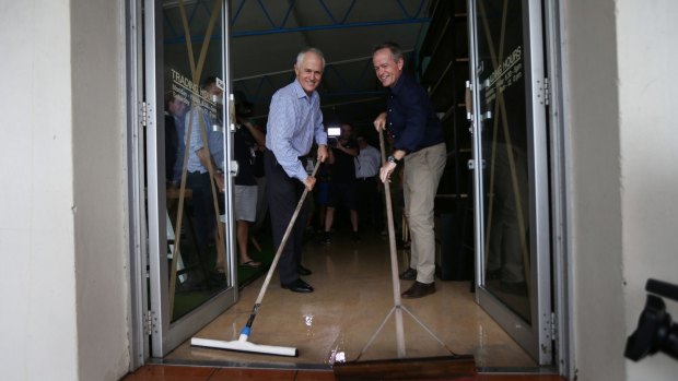 Prime Minister Malcolm Turnbull and Opposition Leader Bill Shorten help with clean-up efforts in Bowen, Queensland on Thursday.