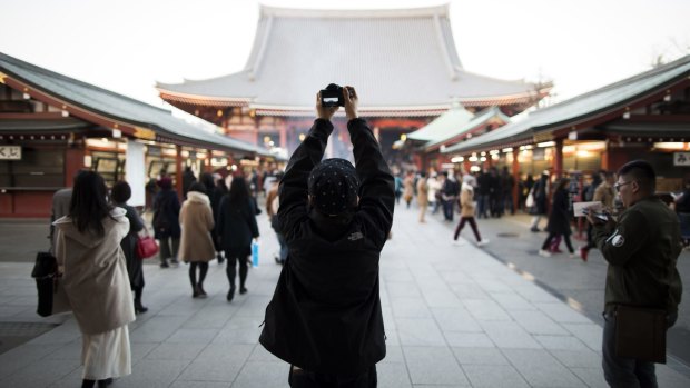 A Chinese tourist takes a photograph at the Sensoji temple in the Asakusa district of Tokyo.