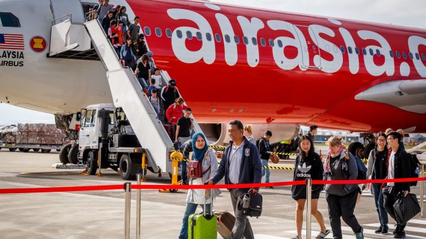 Passengers walks across the tarmac after arriving on AirAsia X's inaugural flight to Avalon from Kuala Lumpur.