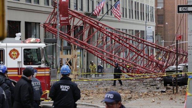 A collapsed crane lies on the street on Friday in New York.  