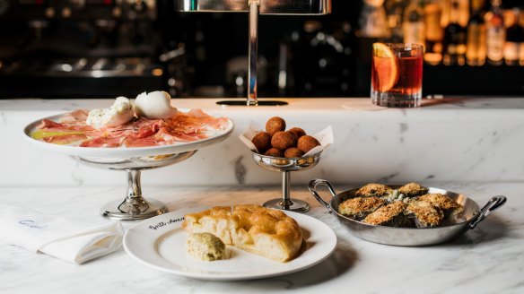 Venetian-style snacks on the bar at Grill Americano, including salumi, potato focaccia with green olive butter, chicken croquettes and oysters Americano.