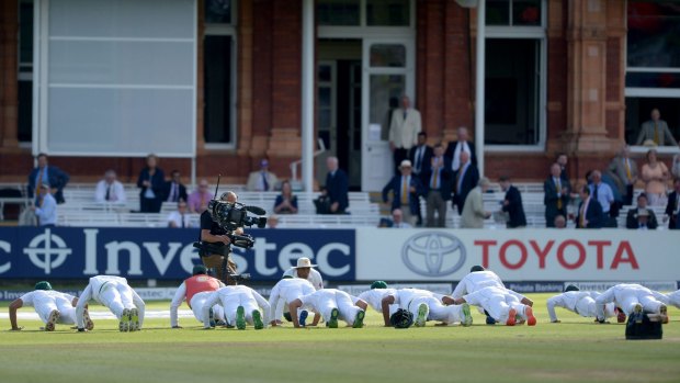 The Pakistan team celebrate winning their match against England by doing push-ups on the pitch.