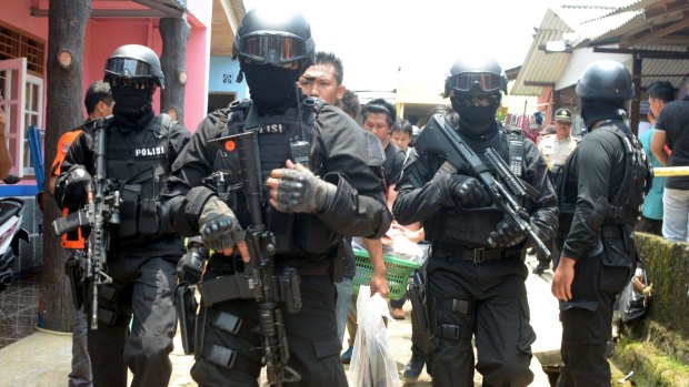 Armed anti-terror police escort bags of evidence from the house of a man suspected of being involved in Islamic State-related activities in Tangerang, Indonesia, earlier this month.