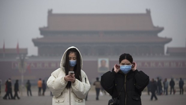 Visitors wear masks to protect against pollution in Tiananmen Square, Beijing.