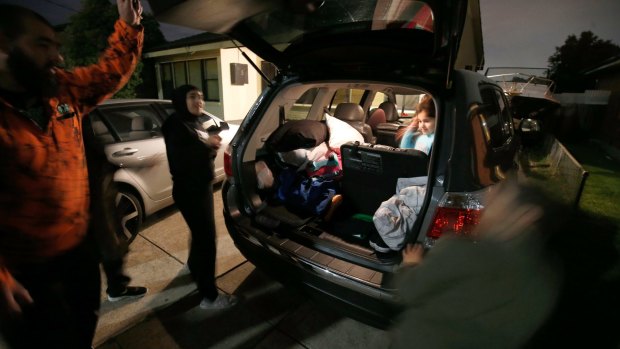 Dallas residents Hassan and Helen Halwani and their four children pack their car to flee Dallas late Thursday night.