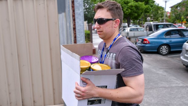 A detective carries a box of the stolen baby formula.