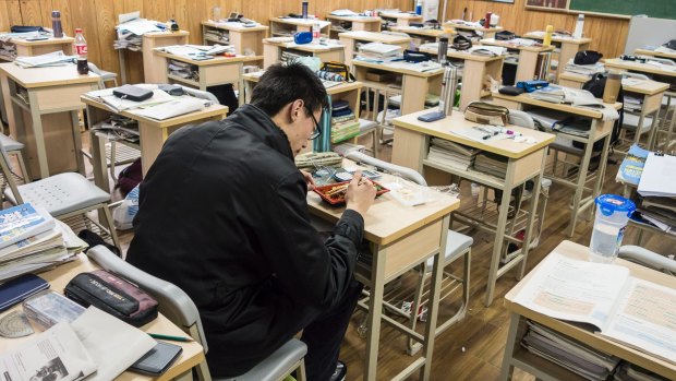 A student eats his lunch while sitting in his classroom at Shanghai High School in Shanghai, China. 