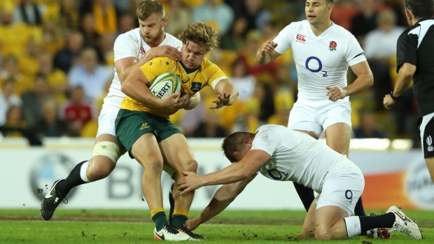 What a game: Michael Hooper is tackled by England duo George Kruis and Dylan Hartley.