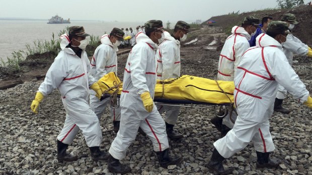 Rescue workers carry a body recovered from a capsized cruise ship in the Yangtze River in southern China's Hubei province, on Thursday.