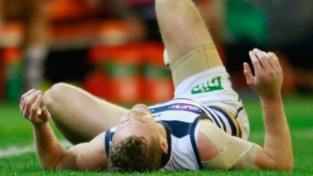 Feeling down: Geelong captain Joel Selwood falls to the ground after injuring his right hand.