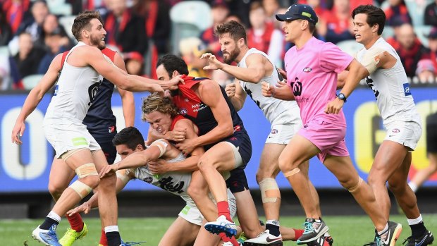 Carlton and Melbourne players wrestle during their round two match at the MCG. 