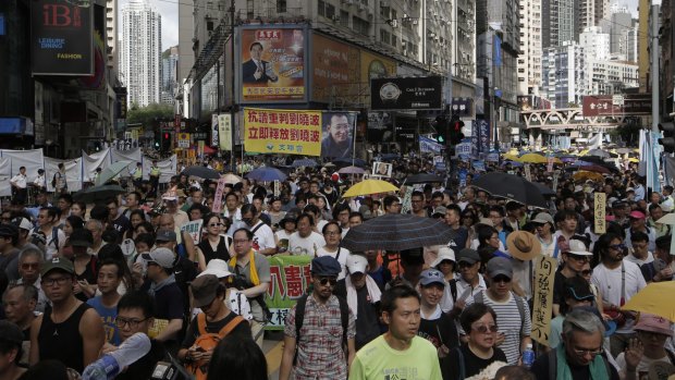 Hundreds of protesters march along a downtown street during the annual pro-democracy protest in Hong Kong.