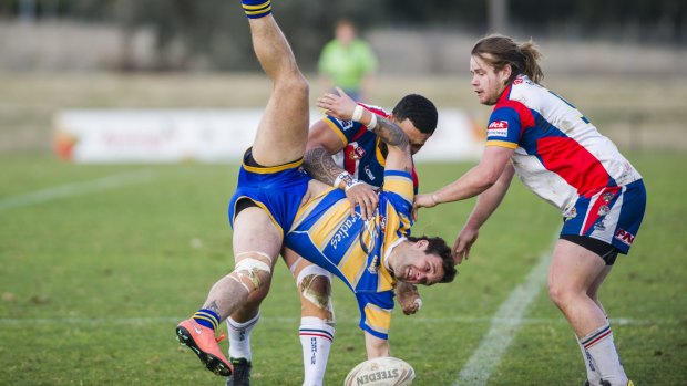 Woden's Jesse Taws is thrown to the ground in a tackle with Tuggeranong's Atunaisa Tupou.