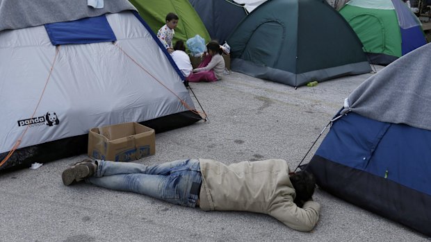 A man sleeps on the ground in the Athens' port of Piraeus on Monday.