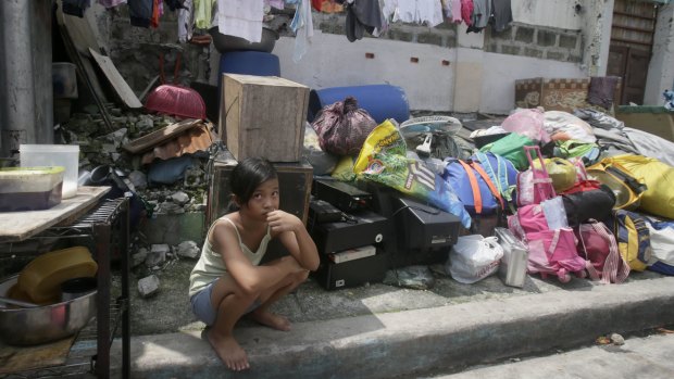 An informal settler guards her belongings as demolition begin to demolish their houses in Quezon city, north-east of Manila, in September.