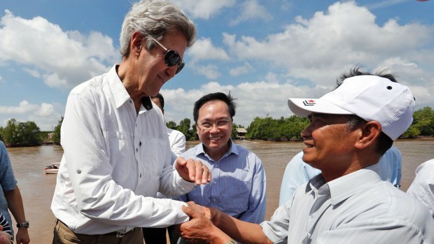 US Secretary of State John Kerry, left, shakes hands with Vo Ban Tam, 70, right, who was a Viet Cong guerrilla and took part in the attack on Kerry's Swift Boat in February 1969.
