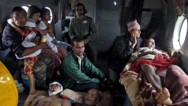 Victims of Saturday's earthquake rest inside an Indian Air Force helicopter as they are evacuated from Trishuli Bazar to the airport in Kathmandu, Nepal.
