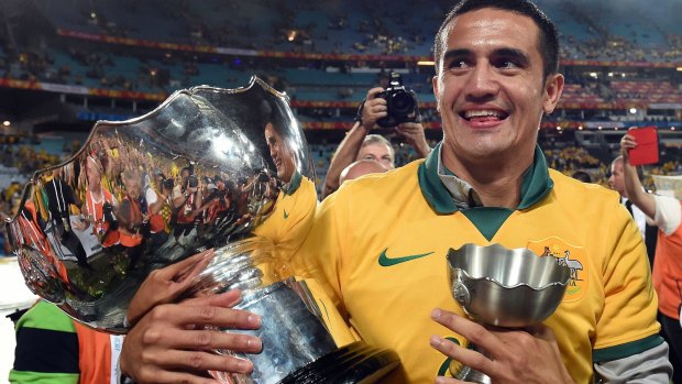 Tim Cahill, here holding the Asian Cup, is committed to playing in China for at least one season.
