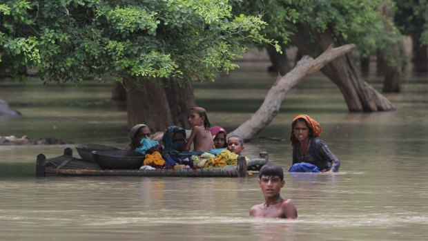 Pakistani villagers wade through floodwaters in Rajanpur.